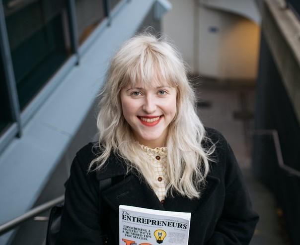 Woman standing in stairs, with a magazine in hand