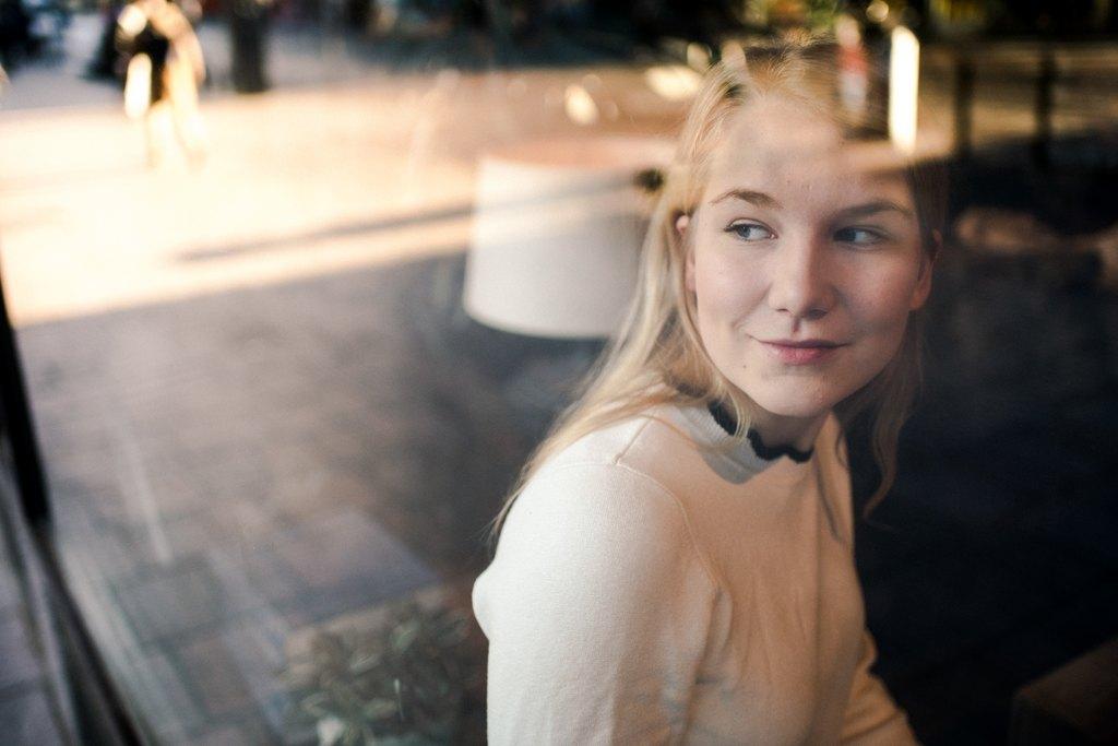 A girl sitting by the window looking out