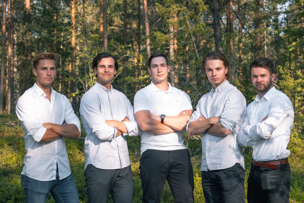 Brightlife tiimin viisi jäsentä seisoo rivissä kädet ristissä valkoisissa paidoissa ja tummissa housuissa. Taustalla vehreä metsä.