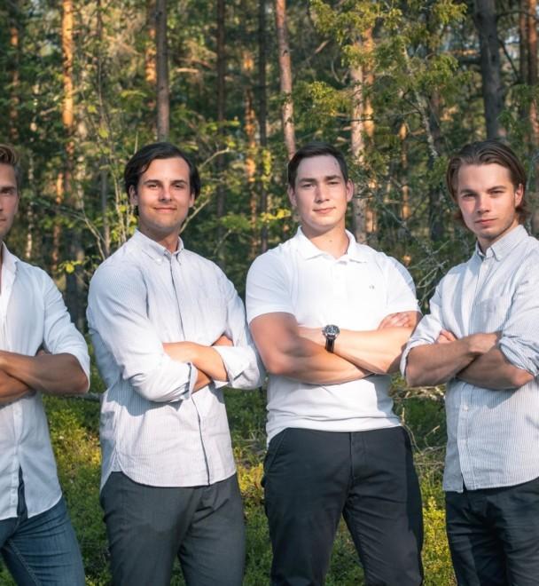 Brightlife tiimin viisi jäsentä seisoo rivissä kädet ristissä valkoisissa paidoissa ja tummissa housuissa. Taustalla vehreä metsä.