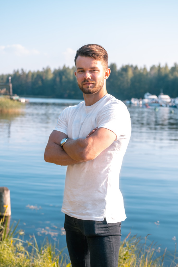 Eero standing outside on a sunny day,  in front of a lake