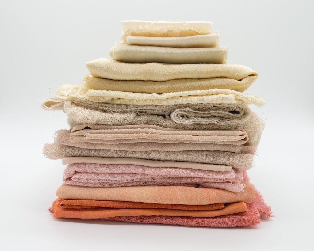 A pile of soft coloured textile on a white background