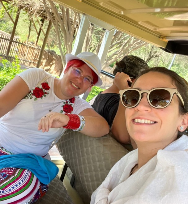 Cristina and Sara sitting on a vehicle and smiling at the camera.