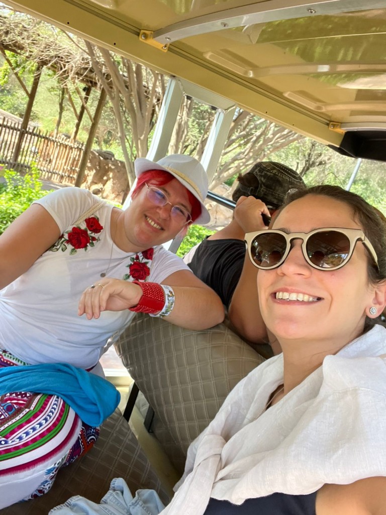 Cristina and Sara sitting on a vehicle and smiling at the camera.