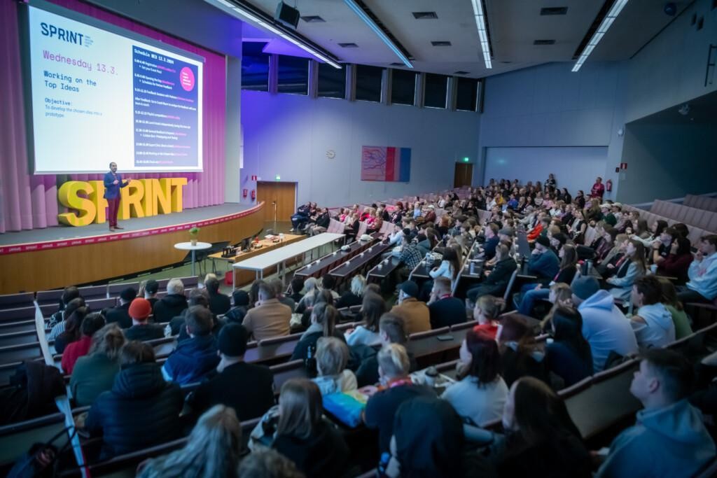 Audience facing a stage.